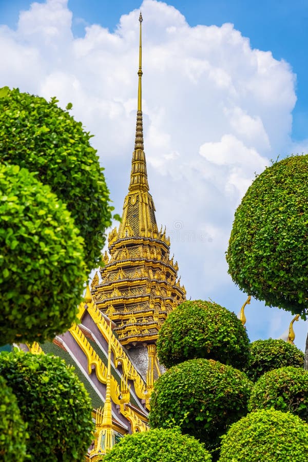 Golden spire of the Grand Palace in Bangkok against a clear blue sky
