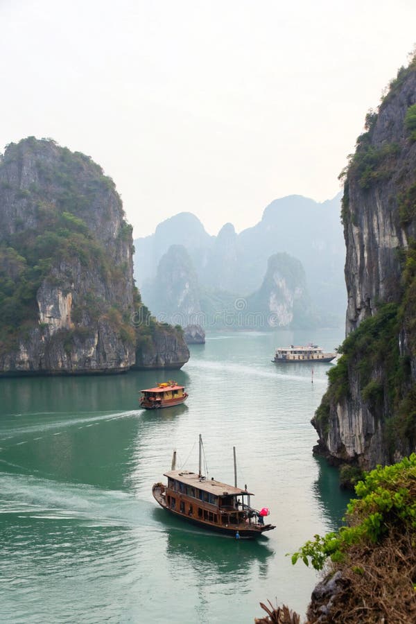 Traditional wooden boat cruising among the limestone karsts of Ha Long Bay